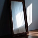 Ein einzelner Spiegel reflektiert weiches Licht – Symbol für Selbstreflexion, Stille und die Suche nach Tiefe.