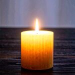 Eine einzelne Kerzenflamme in weicher Dunkelheit – Symbol für Leben, Hingabe und Inspiration.