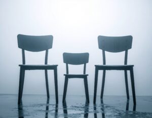 Trauer bewältigen nach Verlust: Drei leere Stühle symbolisieren den Tod von Großvater, Vater und Sohn